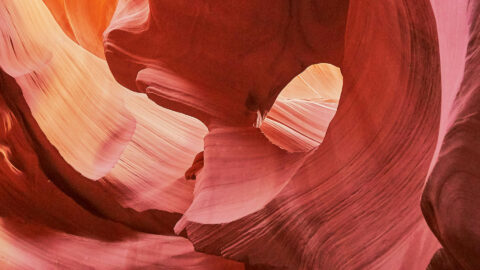 Smooth red sandstone walls lit by bright sunlight.