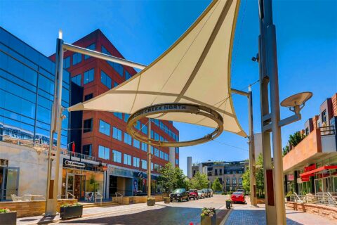 Cherry Creek North with bustling shops, ample parking, and large sun sail with signage.